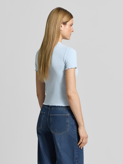 Frauenmodel trägt T-Shirt mit Wellensaum von Jake*s Casual in Hellblau, körpernaher Schnitt, Feinripp, Rundhalsausschnitt, Baumwoll-Mix mit Stretch-Anteil, Ganzkörperansicht Rückansicht.