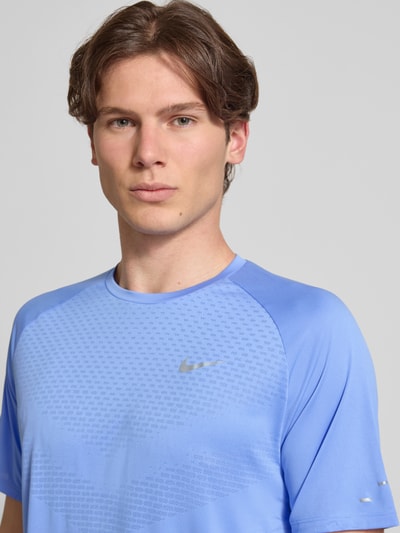 Männermodel trägt Funktionsshirt mit Logo und Rundhalsausschnitt Modell 'Stride' von NIKE TRAINING in Blau, Regular-Fit, Nahaufnahme Oberkörper. Rückenlänge bei Größe M: 73 cm.