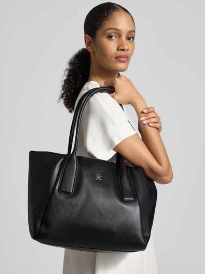 Frauenmodel trägt Shopper in Leder-Optik von Tommy Hilfiger, Optik: Unifarben, Logo-Applikation aus Metall, Tragehenkel, Nahaufnahme Oberkörper.