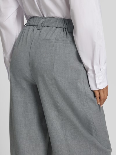 Frauenmodel trägt relaxed Fit Gerade Hose mit Bundfalten Modell 'Metta' von OPUS PANTS in Hellgrau, feine Textur, Detailaufnahme Rückansicht.