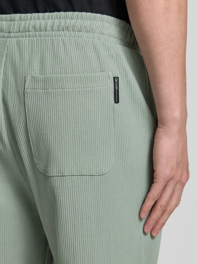 Männermodel trägt Relaxed Fit Sweatshorts aus reiner Baumwolle von Tom Tailor Denim, Optik: Unifarben, Gesäßtasche, Rippstrick, Nahaufnahme Rückansicht.