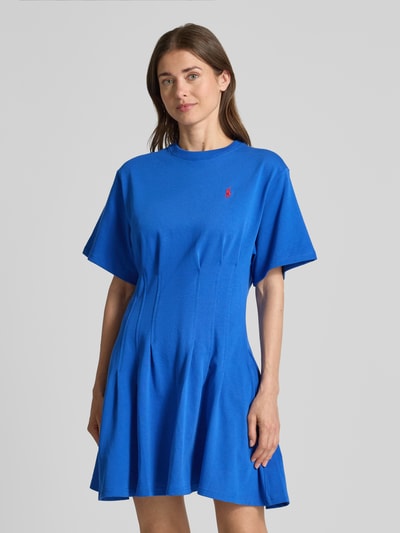 Modelka kobieca nosi Leicht ausgestelltes Sweatkleid aus reiner Baumwolle od Polo Ralph Lauren w kolorze melanżowym niebieskim, lekko rozszerzany fason, długość mini, okrągły dekolt, krótki rękaw, logo na piersi, fałdy, materiał dresowy z czystej bawełny, zdjęcie całej sylwetki od przodu.