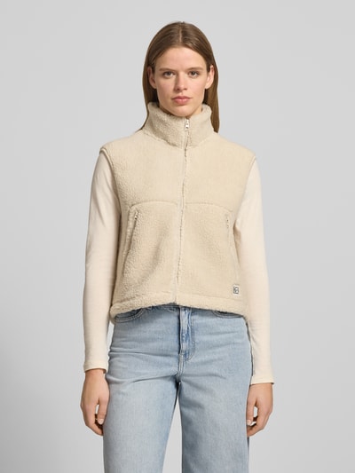 Vrouwenmodel draagt Weste aus Teddyfell mit Stehkragen Modell 'MASEY' van Noisy May in beige, rechte fit, label-patch, frontaal bovenlichaam close-up.