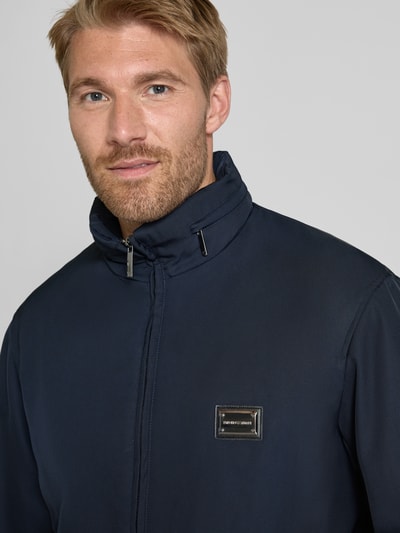 Männermodel trägt Regular Fit Jacke mit Stehkragen von Emporio Armani, dunkelblau, Logo-Applikation, Nahaufnahme Oberkörper.
