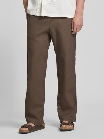 Männermodel trägt Leinenhose mit elastischem Bund und Eingrifftaschen von GAP in Braun, Loose Fit, Nahaufnahme Unterkörper, Vorderansicht.