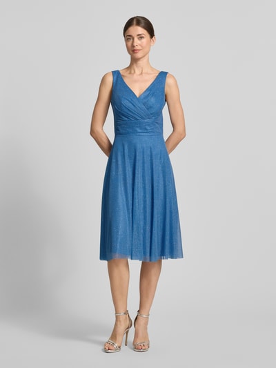 Frauenmodel trägt knielanges Cocktailkleid mit V-Ausschnitt von TROYDEN COLLECTION aus blauem Chiffon, Taillierter Schnitt, Breite Träger, Ganzkörperansicht von vorne. Rückenlänge bei Größe 36: 85 cm, Brustweite bei Größe 36: 43 cm, mit rückseitigem V-Ausschnitt und Rückenreißverschluss.