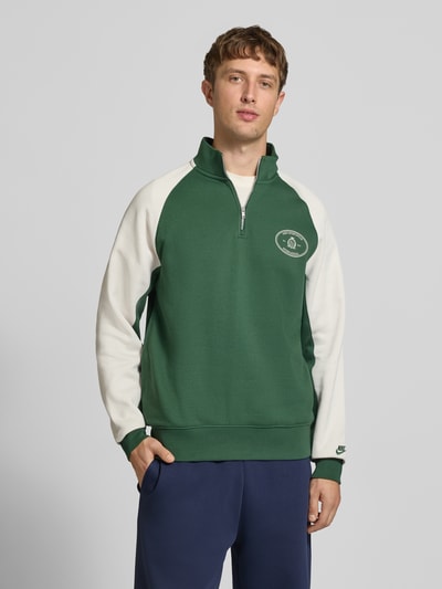 Männermodel trägt Relaxed Fit Sweatshirt aus Baumwoll-Mix von Nike in Dunkelgrün und Weiß, glatte Oberfläche, Ganzkörperansicht von vorne. Herren Sweatshirt von Nike