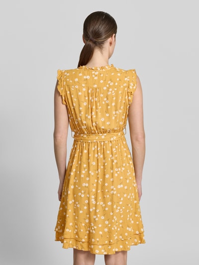 Frauenmodel trägt Minikleid aus Viskose mit Bindegürtel und Kappärmeln von Apricot in Gelb mit weißen Blümchen, Stufenrock, Rückenlänge 89 cm, taillierter Schnitt, Ganzkörperansicht Rückansicht.