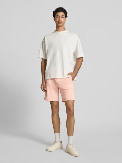 Männermodel trägt Sweatshorts mit Stitching Modell 'KARL' von Jack & Jones in Hellrosa, Baumwoll-Mix, Regular Fit, Ganzkörperansicht von vorne.