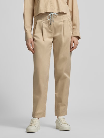 Vrouwenmodel draagt Straight Fit Stoffhose mit Tunnelzug van Marc Cain in beige, katoenmix, plooien, deels elastische taille, vooraanzicht, detailopname.