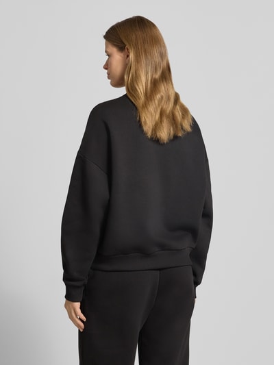 Frauenmodel trägt Basic Sweater mit Rundhalsausschnitt und Bündchen am Ärmel von Review, oversized, Gerippte-Abschlüsse, Ganzkörperansicht Rückansicht.