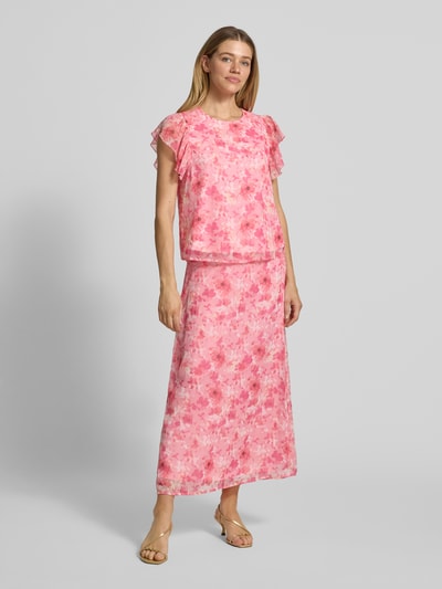 Vrouwenmodel draagt uitlopend model Ausgestellter Maxi-Rock met elastische band model 'SMILLA' van Vero Moda, look: effen, maxilengte, materiaalverwerking: chiffon, bloemenmotief, onderrok, boord, recht, gebroken wit en roze tinten. Volledige lichaamsaanzicht van voren.