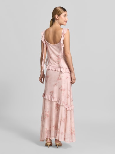 Frauenmodel trägt Maxikleid aus Mesh Modell 'Adelle' von Neo Noir in Rosa mit Allover-Look und Rüschen, Ganzkörperansicht Rückansicht.