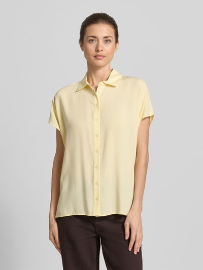 Frauenmodel trägt Regular Fit Bluse aus Viskose von Christian Berg Woman in zartem Gelb mit Hemdblusenkragen, Knopfleiste, Ganzkörperansicht von vorne. Rückenlänge bei Größe 36: 64 cm, Ärmellänge bei Größe 36: 15 cm.