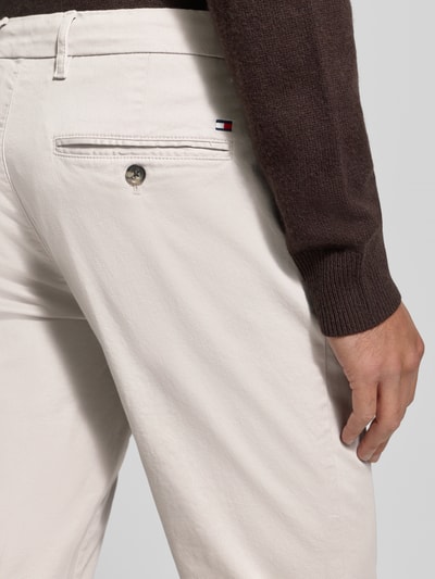 Männermodel trägt Slim Fit Chino aus Baumwoll-Mix Modell 'BLEECKER' von Tommy Hilfiger, Optik: Unifarben, Detailaufnahme Rückansicht.