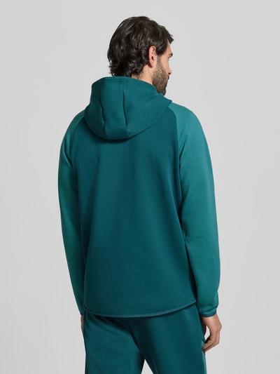 Männermodel trägt Regular Fit Jacke mit Kapuze Modell 'Unstoppable' von Under Armour, Elastischer-Material-Mix, Rückenansicht Ganzkörperansicht.
