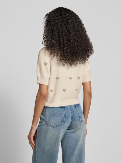Vrouwenmodel draagt Slim fit gebreid jack met all-over bloemenmotief model 'DOFFY INTARSIA' van Vero Moda, effen look, romp/mouwboord geribd, korte mouw, knoopsluiting, ronde hals, materiaalverwerking: knitwear. Volledige lichaamsweergave achterkant.