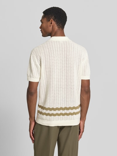 Männermodel trägt Regular Fit Strick-Poloshirt Modell 'HOLLA' von Casual Friday aus reiner Baumwolle, Ganzkörperansicht Rückansicht. Durchgehende Knopfleiste, Rückenlänge bei Größe M 70 cm, Ärmellänge 23 cm, dezentes Loch-Strick-Design in Weiß und Olive.