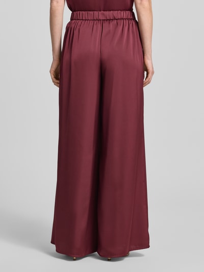 Frauenmodel trägt Wide Leg Hose aus Satin mit elastischem Bund von V by Vera Mont in Dunkelrot, lockerer Schnitt, Ganzkörperansicht Rückansicht.