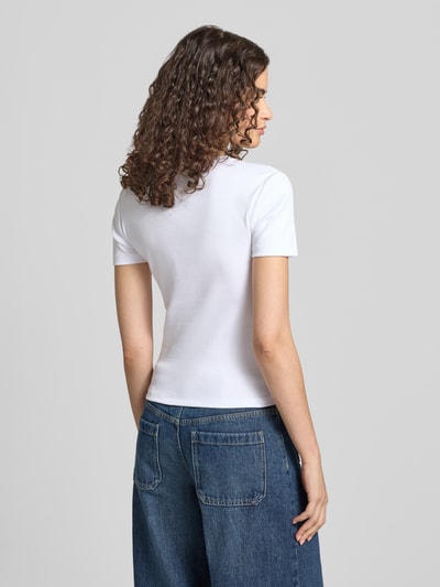 Frauenmodel trägt weißes Regular-Fit Damen T-Shirt aus Baumwoll-Mix Modell 'VAL' von ONLY, glatte Oberfläche, Ganzkörperansicht Rückansicht.