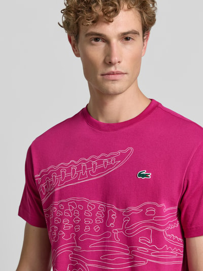 Mężczyzna nosi Regular Fit Sport-T-Shirt aus Baumwoll-Mix von Lacoste w kolorze fuksji z nadrukiem, Herren sport t-shirt von Lacoste Sport, zbliżenie na górną część ciała