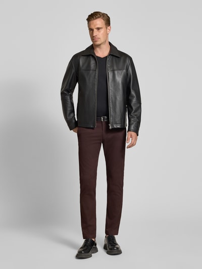 Männermodel trägt Slim Fit Chino aus Baumwoll-Mix von bugatti in Braun, sichtbarer Knopfverschluss, schlichte Textur, Ganzkörperansicht von vorne. Elastischer Baumwoll-Mix, Gesäßtaschen, Münztasche.
