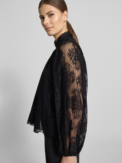 Vrouwenmodel draagt Regular Fit Bluse aus Spitze mit Stehkragen van Rinascimento, zwarte kanten stof, katoenmix, lange mouw, semi-transparant, zijaanzicht bovenlichaam.