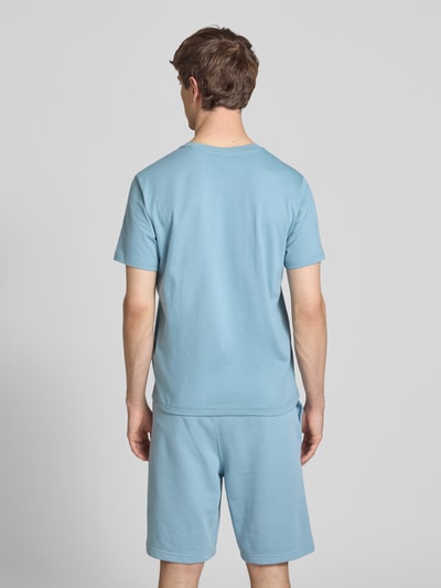 Mężczyznamodel nosi T-Shirt mit Label-Stitchings und Rundhalsausschnitt von CHAMPION, bawełna, krój regular fit, długość tyłu 69 cm, widok całej sylwetki z tyłu.