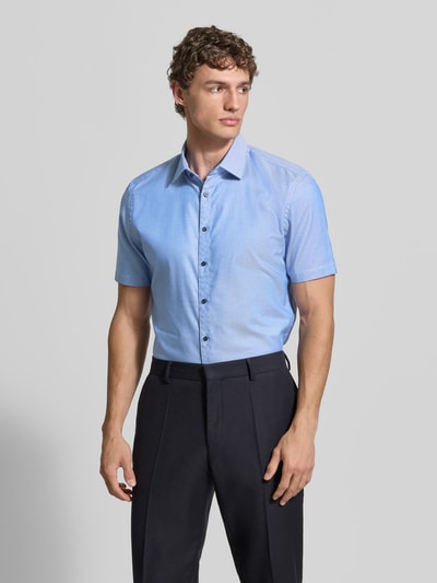 Männermodel trägt Slim Fit Business-Hemd aus Baumwolle mit Kentkragen von Jake*s in Hellblau, Knopfleiste, Ganzkörperansicht von vorne.