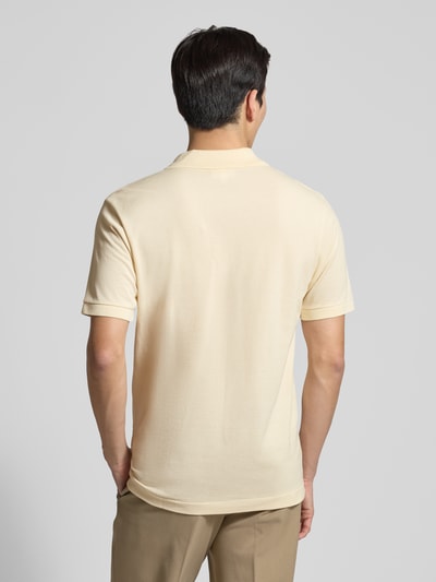 Männermodel trägt Regular Fit Poloshirt aus reiner Baumwolle von Lacoste in Unifarben, Piqué-Textur, Logo-Stitching, Ganzkörperansicht Rückansicht.