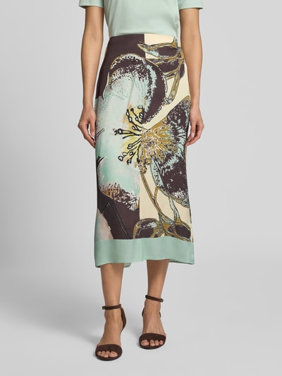 Frauenmodel trägt Midirock aus Viskose im Allover-Look von Marc Cain, gerader Schnitt, florales Muster, Reißverschluss, Ganzkörperansicht von vorne.
