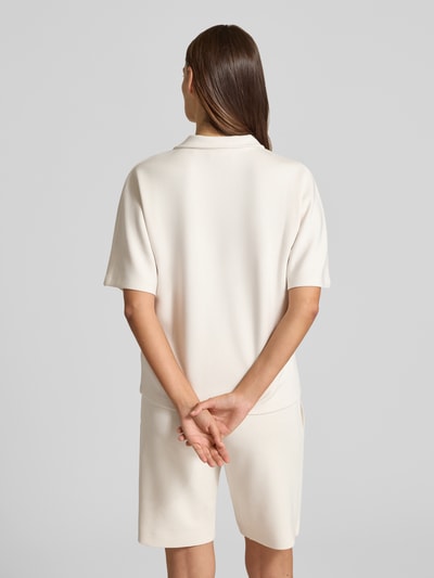 Frauenmodel trägt Regular Fit Poloshirt mit V-Ausschnitt von Christian Berg Woman aus mieszanka materiałów z domieszką modalu, rękaw o dł. 1/2 w jasnym kolorze, gładka faktura, Ganzkörperansicht Rückansicht.
