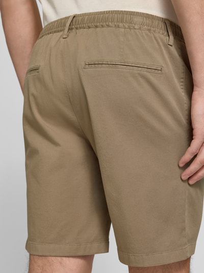 Männermodel trägt Straight Fit Shorts mit Bundfalten von Profuomo in Beige, elastischer Bund, Eingrifftaschen, Nahaufnahme Rückansicht.