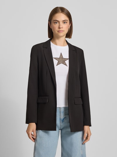 Frauenmodel trägt schwarzen Regular Fit Longblazer mit Leo-Innenmuster Modell 'BOZZY' von PIECES, weißes Shirt, blaue Jeans, Ganzkörperansicht von vorne, Damen Longblazer von PIECES.