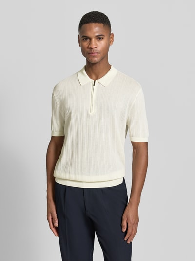 Männermodel trägt Body Fit Poloshirt mit kurzem Reißverschluss von Emporio Armani aus reiner Baumwolle, helle Farbe, gerippte Struktur, Ganzkörperansicht von vorne.