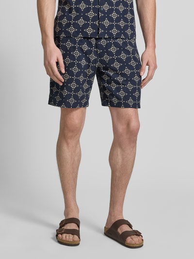 Mannelijk model draagt Relaxed Fit Stoffshorts uit katoen van s.Oliver RED LABEL met donkerblauw-wit patroon, detailopname benen.