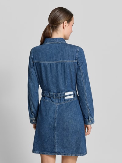 Frauenmodel trägt Jeanskleid mit Taillengürtel von Tom Tailor Denim in klassischer Denim-Optik, mittleres Blau, reine Baumwolle, Ganzkörperansicht Rückansicht.