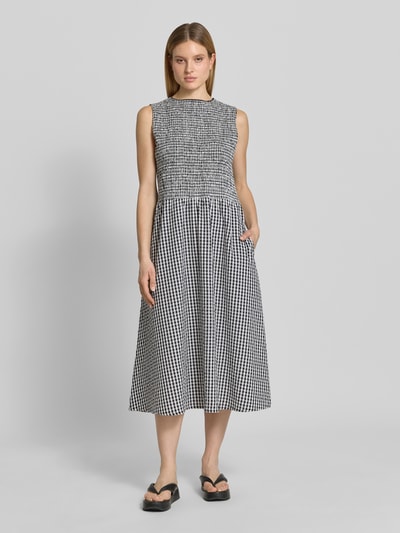Frauenmodel trägt Midikleid mit Smok-Details und Eingrifftaschen von 7578268 aus reiner Baumwolle mit A-Linie und Rundhalsausschnitt, Ganzkörperansicht von vorne.