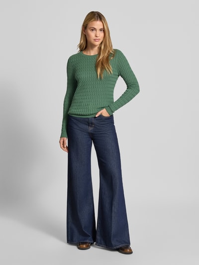 Frauenmodel trägt Slim Fit Strickpullover mit Zopfmuster von Christian Berg Woman in Grün, Baumwoll-Mix, Ganzkörperansicht von vorne.