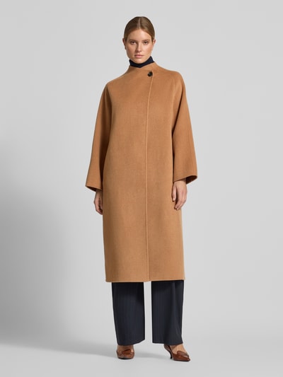 Vrouwenmodel draagt lange wollen jas in camel, opstaande kraag, knoopsluiting, los model, Style Icon Collection, geheel vooraanzicht. Ruglengte maat 36: 124 cm, schouderbreedte: 46 cm, borstwijdte: 62 cm, mouwlengte: 78 cm.