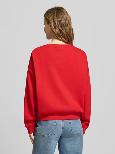 Frauenmodel trägt Oversized Sweatshirt aus Baumwoll-Mix Modell 'SWEAT LIFE' von Only in Rot, unifarben, gerippte Abschlüsse, Ganzkörperansicht Rückansicht.
