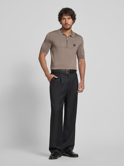 Männermodel trägt Regular Fit Poloshirt aus Viskose-Mix Modell 'SAYFONG-4' von HUGO in effen bruin met label patch, jersey textuur, polokraag, korte knoopsluiting, korte mouwen en geribde boorden. Ganzkörperansicht von vorne.