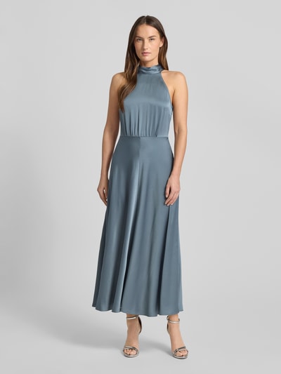 Frauenmodel trägt Maxikleid mit Neckholder Modell 'RHEO' von Samsøe Samsøe in tailliertem Schnitt aus schimmerndem Material-Mix, Ganzkörperansicht von vorne.