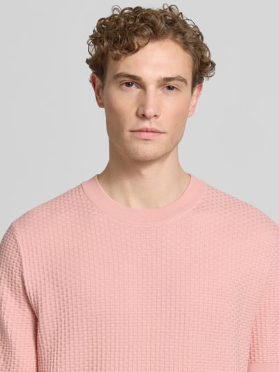 Männermodel trägt Regular Fit Strickshirt aus reiner Baumwolle Modell 'H-NILTON' von BOSS in Optik: Unifarben, Struktur-Nahaufnahme Oberkörper.
