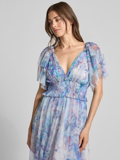 Vrouwenmodel draagt cocktailjurk met smokdetail en V-hals van LACE & BEADS, chiffon, A-lijn, midi-jurk, vlindermouwen, ruglengte maat S 102 cm, borstwijdte maat S 38 cm, mouwlengte maat S 17 cm, pastelkleuren met bloemmotief, detailopname bovenlichaam, schuin van voren.