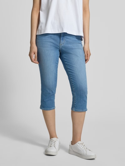 Frauenmodel trägt Slim Fit Caprijeans aus Baumwoll-Mix Modell 'BETSY' von s.Oliver RED LABEL in hellem Denim mit Seitenschlitz, Ganzkörperansicht von vorne.