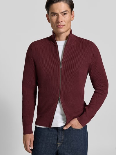 Männermodel trägt Strickjacke mit Stehkragen Modell 'LEVI' von MCNEAL in Bordeaux, Strukturstrick, Baumwoll-Mix, Ganzkörperansicht von vorne.