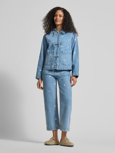 Vrouwenmodel draagt Jeansjacke mit Stitchings und Schnürung van Jake*s Casual in lichtblauw, relaxed fit, opgestikte zakken, bloemenstiksels, omgeslagen kraag, voorkant volledig zichtbaar, lichaamslengte 65 cm, schouderbreedte 43 cm, borstwijdte 53 cm, mouwlengte 58 cm, ganzekörperaanzicht van voren.