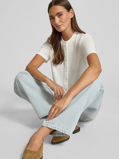 Frauenmodel trägt Strickshirt aus Viskose-Mix mit Knopfleiste von Christian Berg Woman in Weiß, Regular-Fit, Rundhalsausschnitt, Rückenlänge 52 cm bei Größe S, Nahaufnahme Oberkörper.