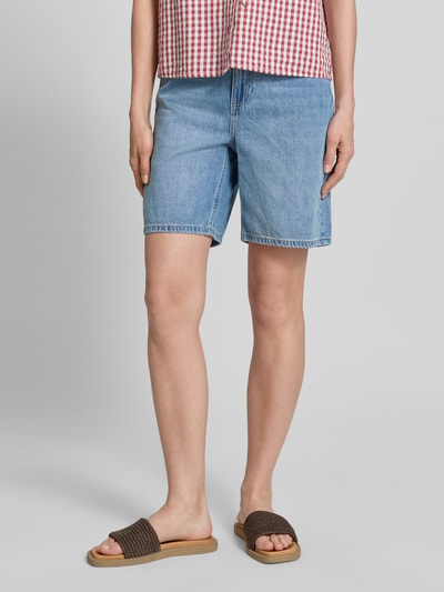 Frauenmodel trägt Regular Fit Bermudas aus Baumwoll-Lyocell-Mix Modell 'VILLA' von Vero Moda, Denim-Optik, 5-Pocket-Design, Ganzkörperansicht von vorne.